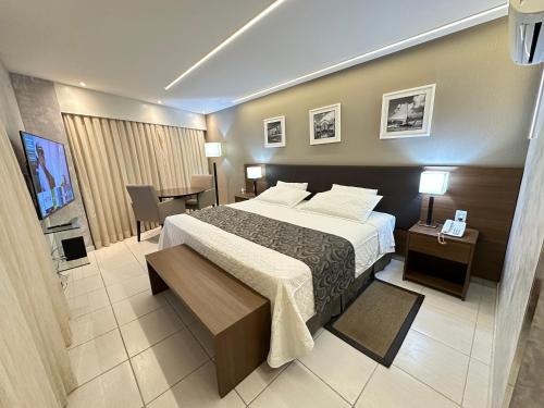 a hotel room with a large bed and a desk at Beach Class Internacional Transamerica in Recife