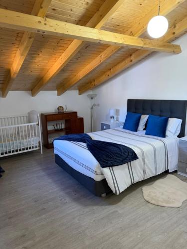 a bedroom with a large bed with blue pillows at Casa da Quinta in Estreito da Calheta