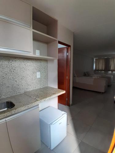 eine Küche mit Arbeitsfläche und ein Zimmer mit einem Bett in der Unterkunft Murano Suits Hotel in João Pessoa