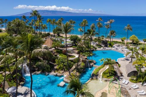 an aerial view of a resort pool with palm trees and the ocean at The Westin Maui Resort & Spa, Ka'anapali in Lahaina