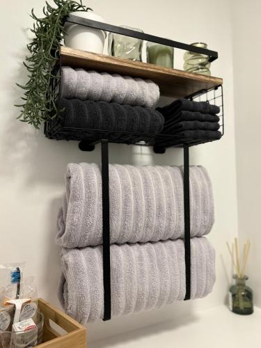 a bunch of towels hanging on a towel rack in a bathroom at The Snug Guestroom Poole in Poole