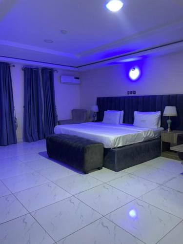 a bedroom with a large bed with purple lighting at Lynstel Apartment & Suites in Abuja
