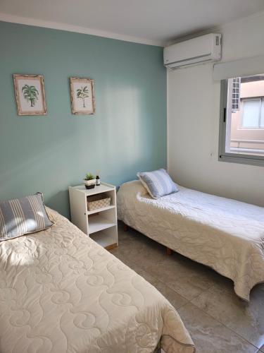 a bedroom with two beds and a window at Amarras pinamar in Pinamar