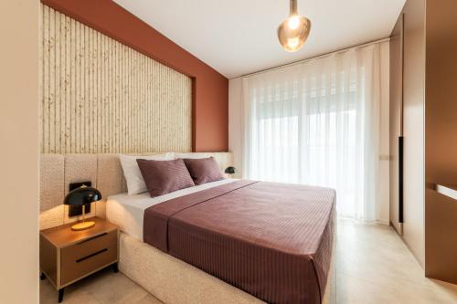 a bedroom with a large bed and a window at Nova Apartments in Prizren