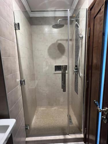 a shower with a glass door in a bathroom at Amirale in Oran