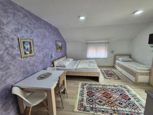 a room with two beds and a table at Apartments City Paradise in Mostar