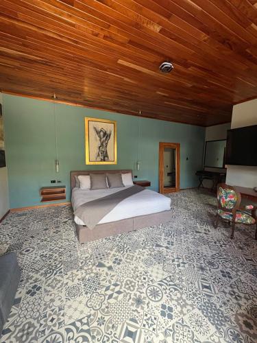ein Schlafzimmer mit einem Bett und einem Fernseher in der Unterkunft Hotel Casa Bataneca in Comitán de Domínguez
