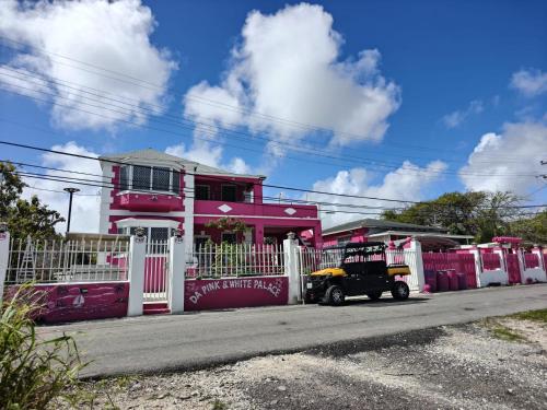 a car parked in front of a pink house at Da Pink And White Palace in Nassau