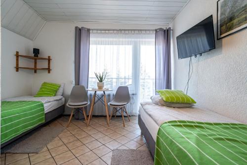 a room with two beds and a table with a window at Dom Czajka nad Jeziorem Wigry in Stary Folwark
