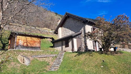 a house on top of a grassy hill at Casa Rongia in Faido