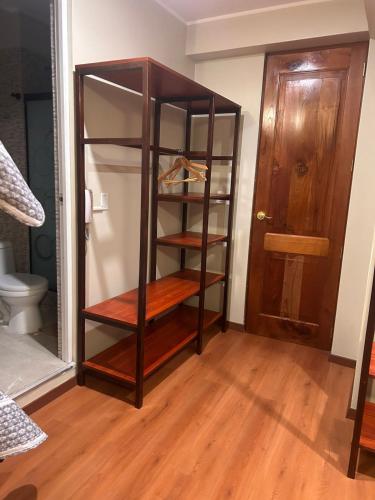 a wooden shelf in a room with a closet at Hotel Makita in Muquiyauyo