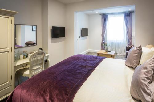 a bedroom with a bed and a desk and a window at The Borough Lancaster in Lancaster