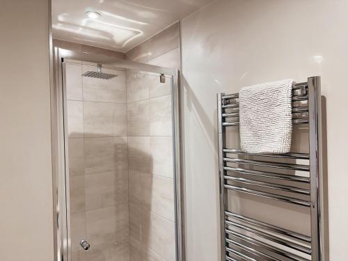 a shower with a glass door in a bathroom at Two Bedroom Warm and Cozy Retreat in Exeter in Exeter