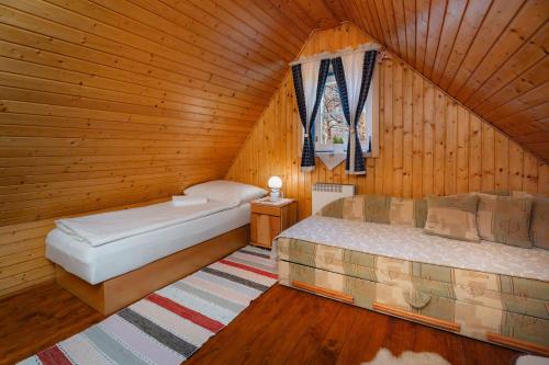 a bedroom with two beds in a wooden room at Chalupa na Samote in Terchová
