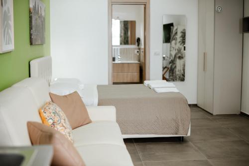 a bedroom with a bed and a white couch at Geranium B&B in Bitonto