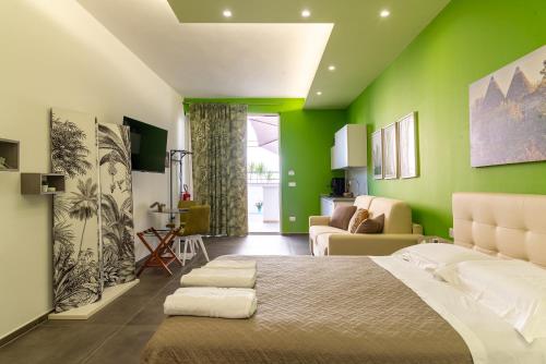 a bedroom with green walls and a large bed at Geranium B&B in Bitonto