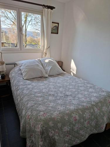 a bed in a bedroom with a window at Vakantiehuis Malaika in Rendeux