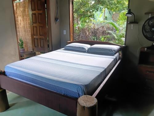 a bed in a room next to a window at Recanto BantuArte-Boipeba in Cairu