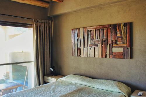 a bedroom with a bed and a painting on the wall at Complejo Piuquenes Valle de Uco in Vista Flores