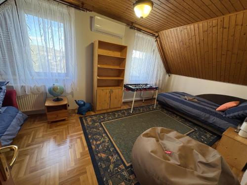 a living room with two beds and a rug at Rigódal Vendégház in Eger