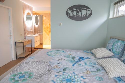 a bedroom with a bed and a bathroom with a sink at Dromen op de Veluwe in Putten