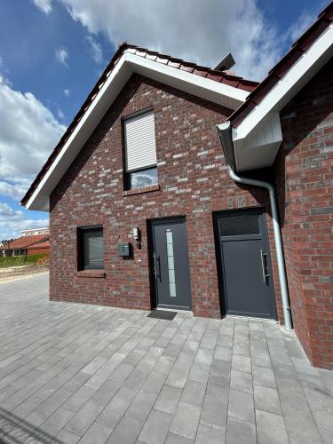 a brick house with two garage doors and a driveway at Seeidylle in Geeste