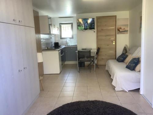 ein Wohnzimmer mit einem Bett und eine Küche mit einer Theke in der Unterkunft STUDIO PIED DANS L EAU in La Londe-les-Maures