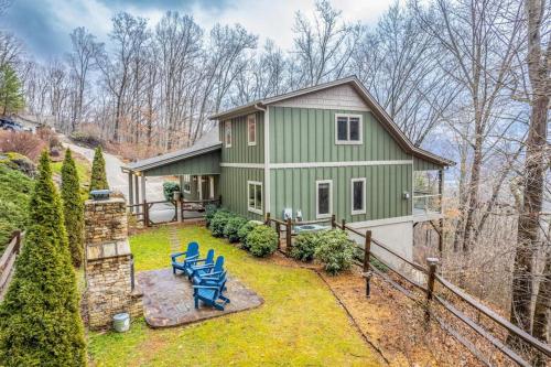a green house with two blue chairs in the yard at Mountain-View Hideaway in Waynesville