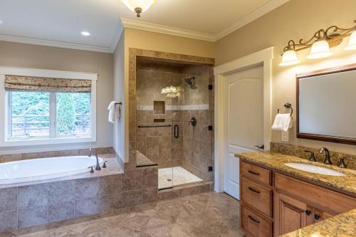 a bathroom with a tub and a shower and a sink at Mountain-View Hideaway in Waynesville