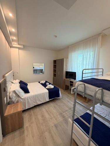 a bedroom with two bunk beds and a desk at Hotel Reggiana in Riccione