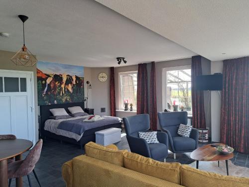 ein Hotelzimmer mit einem Bett und einer Couch in der Unterkunft Dereshoeve in Bunschoten