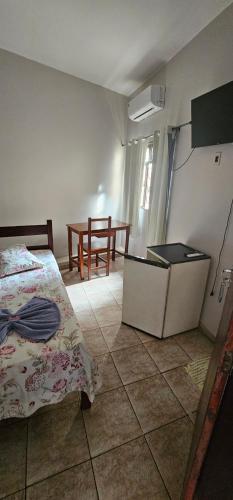 a bedroom with a bed and a table at Hotel Monarca Paracatu in Paracatu