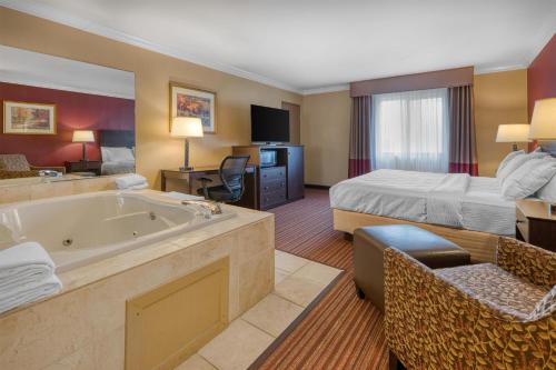 a hotel room with a tub and a bed at Best Western Sycamore Inn in Oxford