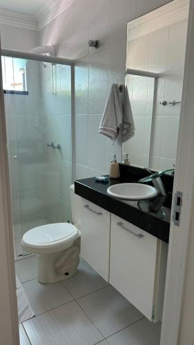 a bathroom with a toilet and a sink and a shower at Summer Beach 300 mt da praia com amplo lazer e mobília nova in Bombinhas