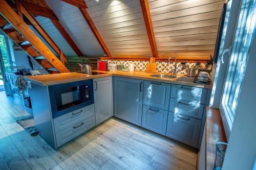 a kitchen with blue cabinets and a wooden ceiling at Cherry garden Cseresznyéskert Vendégház in Dunabogdány