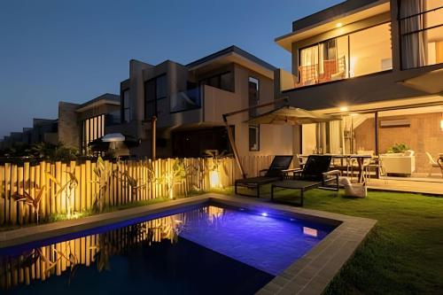 a swimming pool in the backyard of a house at Oka Milagres Beachfront Condominium By MME in Barra do Camaragibe