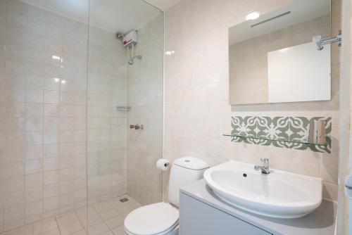 a bathroom with a toilet and a sink and a mirror at Trupial - The green flamingo in Willibrordus
