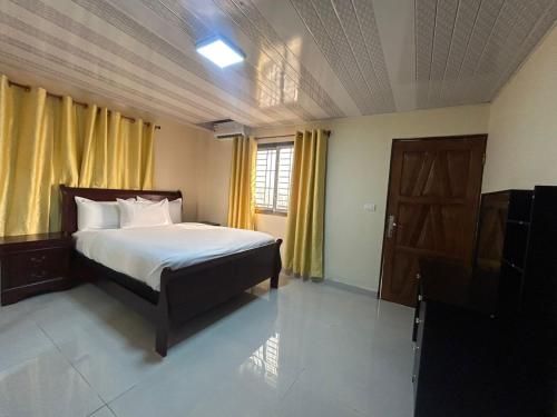 a bedroom with a bed and a window and a door at Moima Plaza Guesthouse in Monrovia