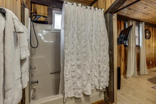a bathroom with a shower curtain and a tub at Great for Groups! Spacious Melcroft Home w/ Deck in Melcroft
