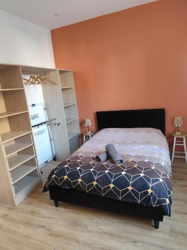 a bedroom with a bed and a orange wall at Jardin De La Sagesse in Sotteville-lès-Rouen