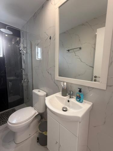a white bathroom with a toilet and a sink at Nova marine 5 in Souda