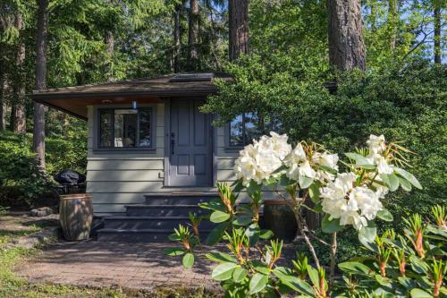 a tiny house in the woods with flowers at Valhalla The Nest in Vesuvius