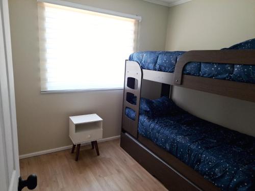 a bedroom with two bunk beds and a window at CABAÑA CON TINAJa in Guanaqueros