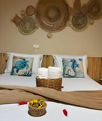 a bedroom with two beds with baskets on the bed at Sua Casa em Noronha - Conforto e Charme na Pousada da Iris in Fernando de Noronha