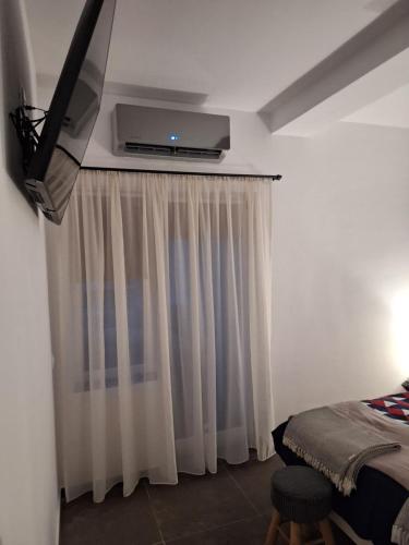 a bedroom with a tv and a window with curtains at Apartament Casa Dia Sibiu in Sibiu