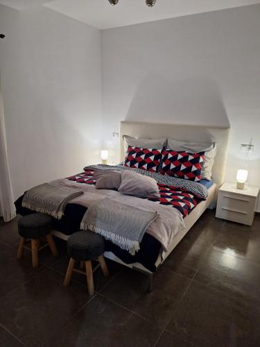 a bedroom with a large bed with two stools at Apartament Casa Dia Sibiu in Sibiu