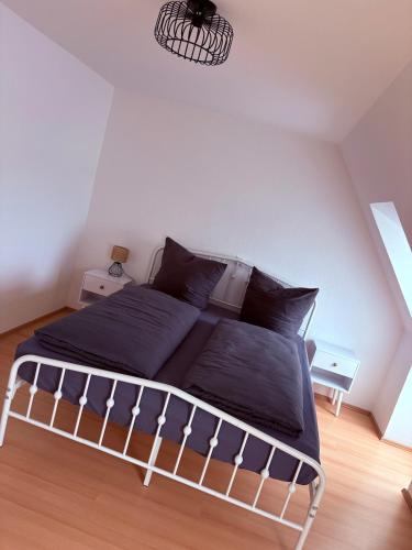 a bed in a bedroom with a white wall at Apartment DümmerSee in Hüde