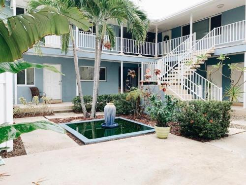 a fountain in front of a house with palm trees at Galleria Apartments By Lowkl in Fort Lauderdale