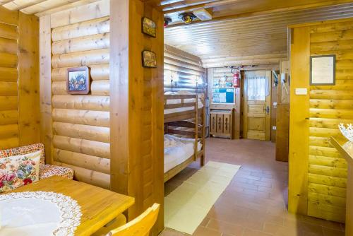 a room with two bunk beds in a log cabin at Appartamenti Leovacanze in Auronzo di Cadore
