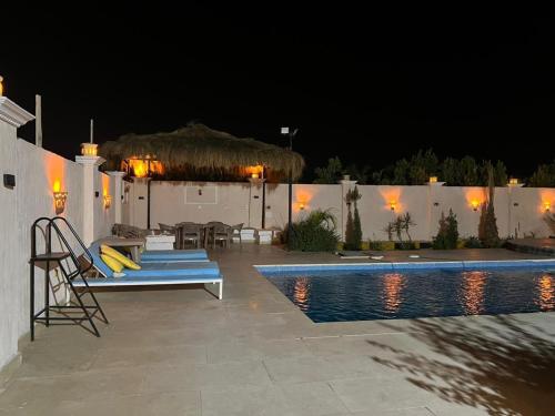 a backyard with a swimming pool at night at شاليه الفهدي in Sphinx International Airport